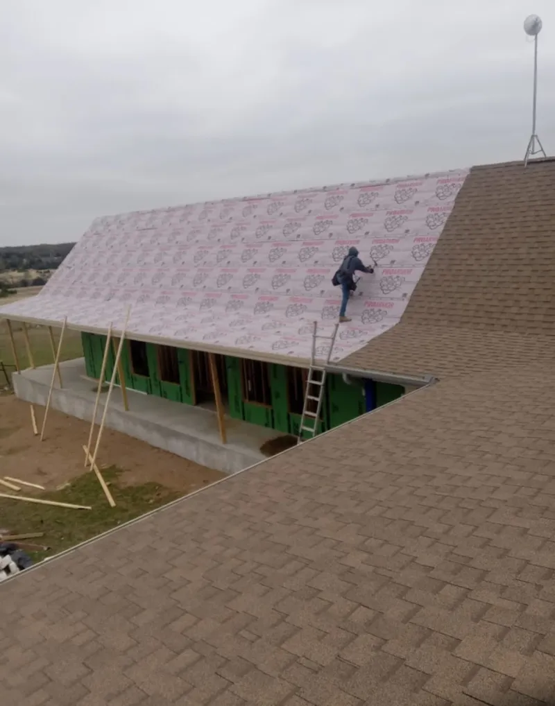 Worker preparing underlayment for a metal roof installation in Thousand Palms